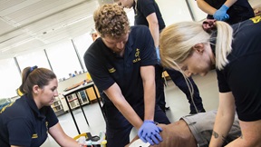 Student paramedics practising resuscitation techniques on a medical mannikin