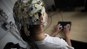 Person wearing electrodes that monitor brain activity, while performing a desk-based task