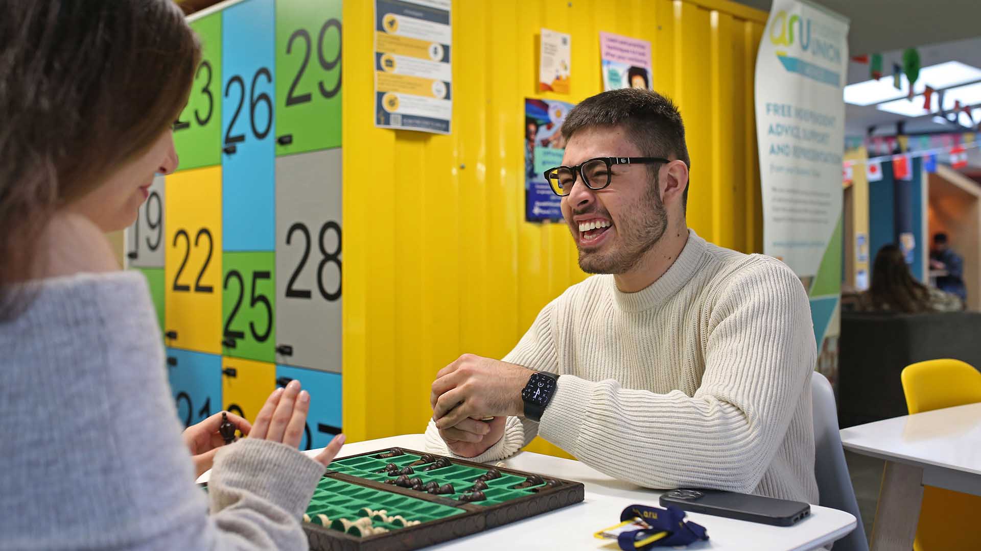 Two students playing a board game in the Students' Union area at ARU Cambridge