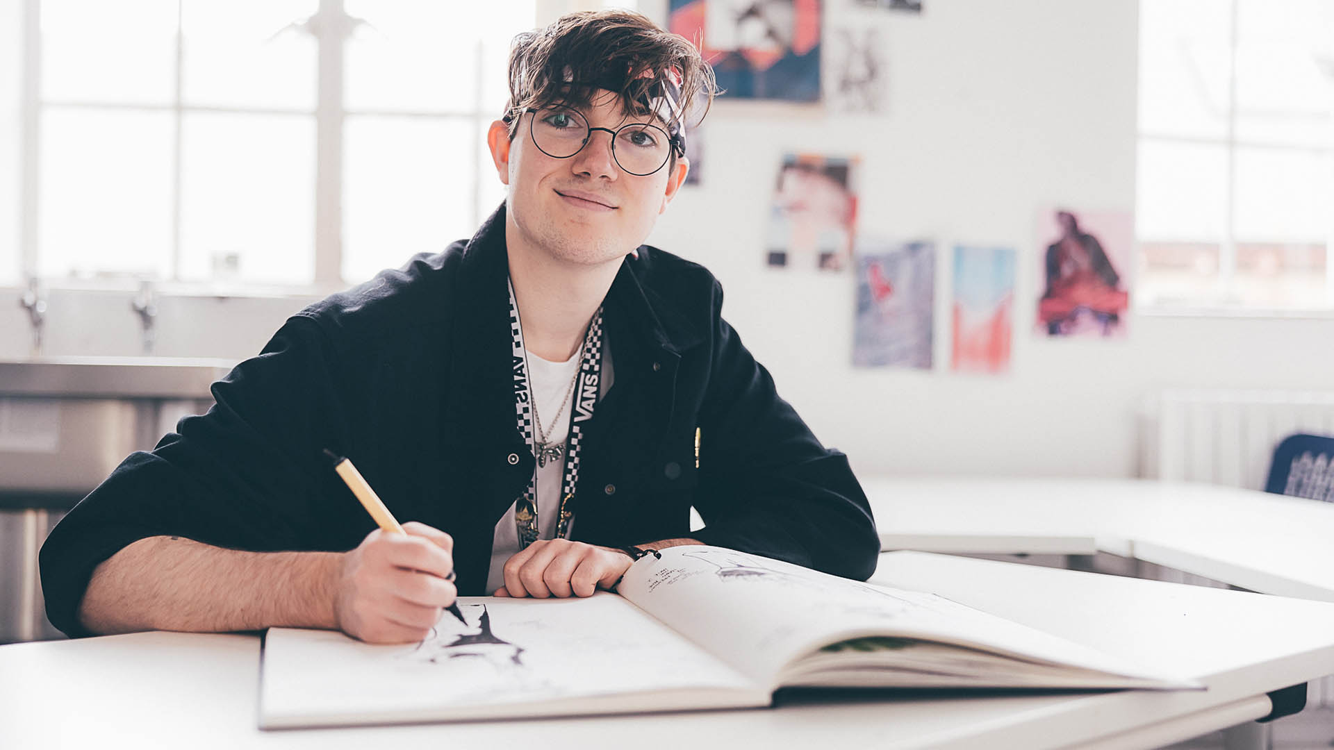 Illustration student in a studio at Cambridge School of Art, drawing in a sketchbook