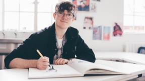 Illustration student in a studio at Cambridge School of Art, drawing in a sketchbook