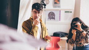 Two fashion students in a studio - one taking photographs and the other art directing