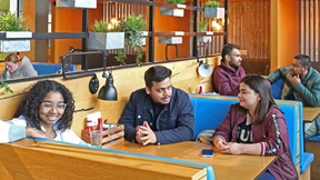 Students seated at tables in 92, the Students' Union restaurant at ARU Chelmsford"