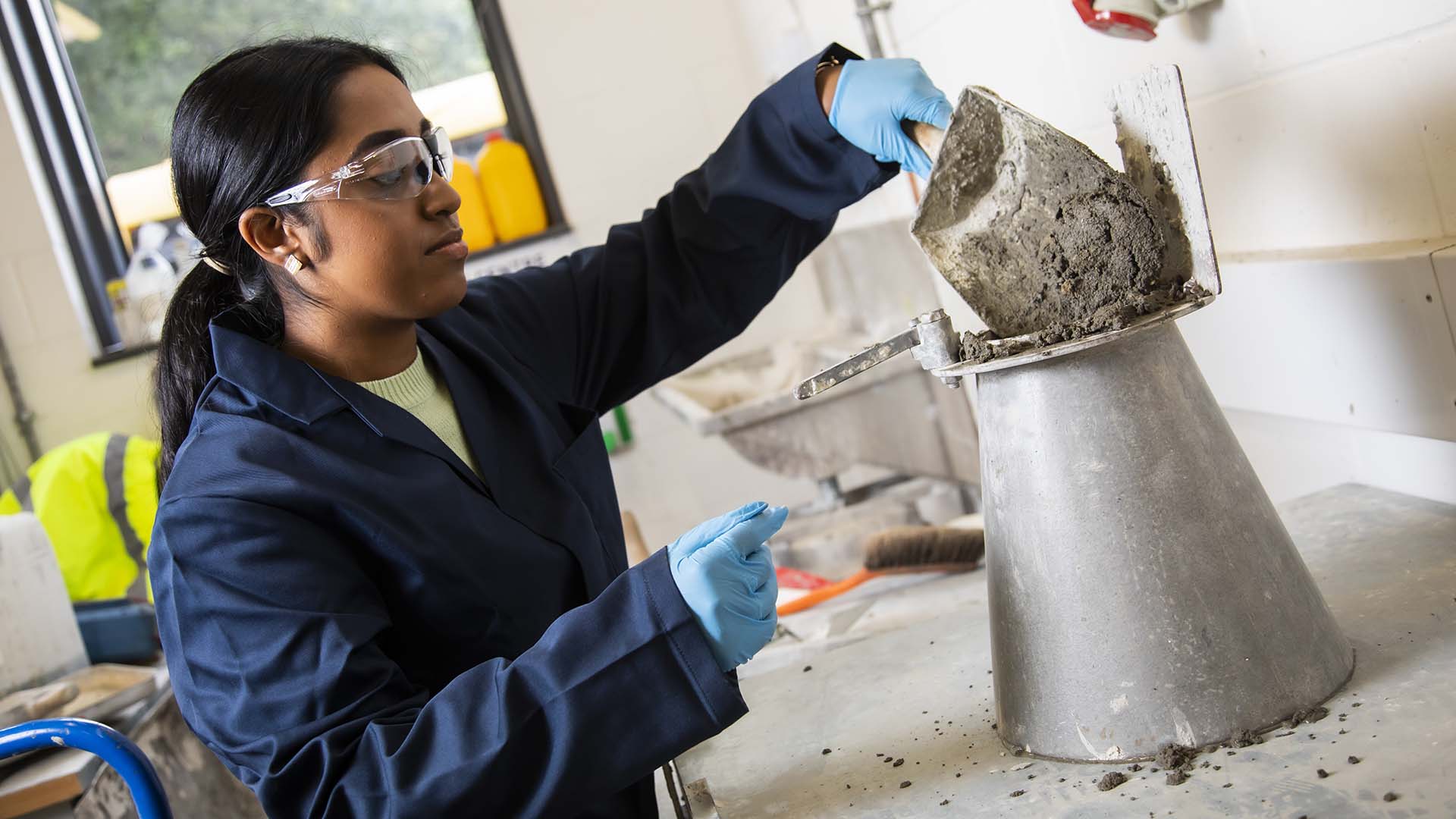Student working with concrete in a civil engineering lab