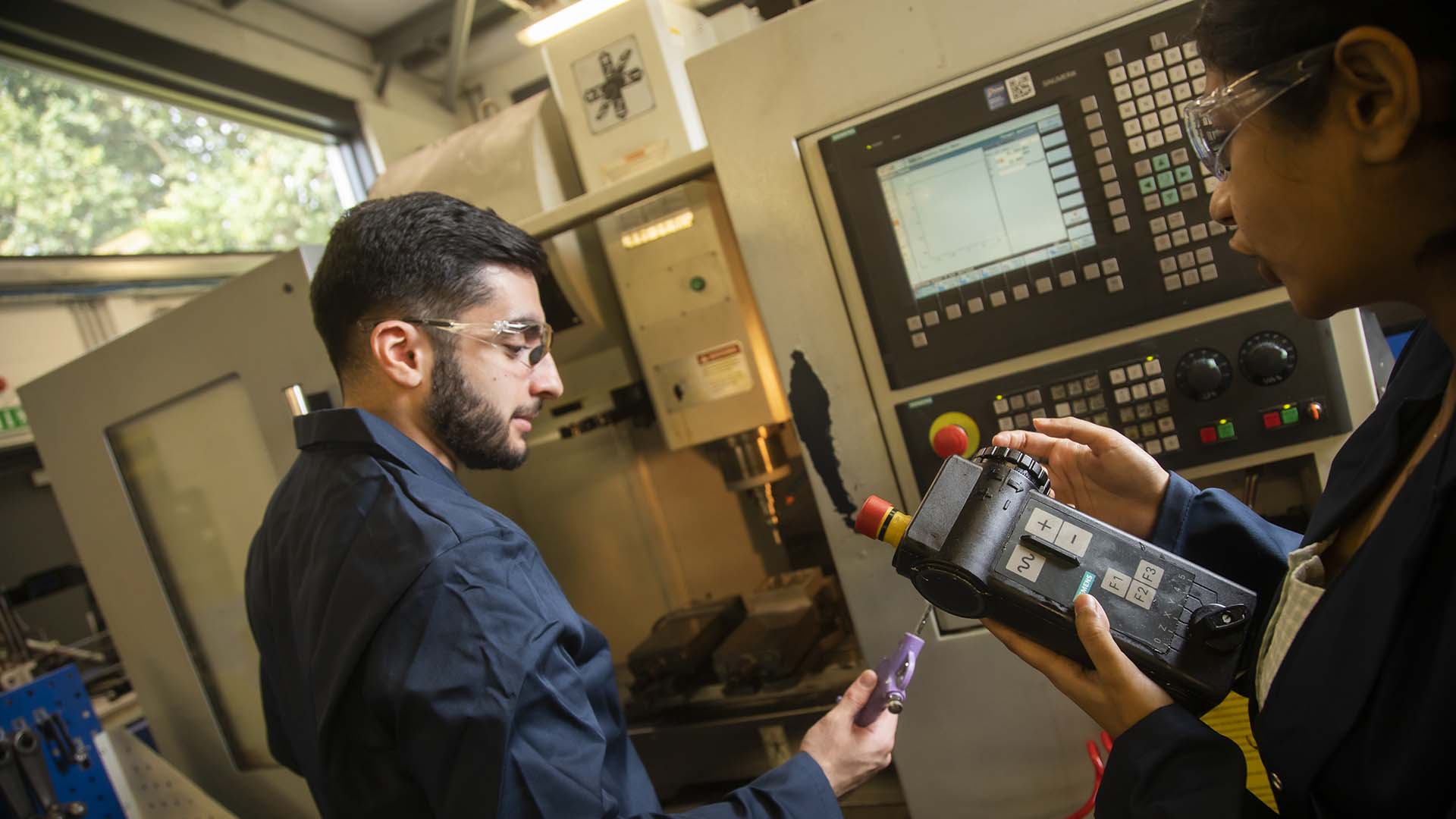 Two students using equipment in a mechanical engineering lab