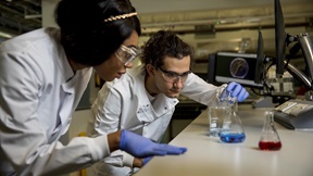 Two students conducting experiments using conical flasks in a medical science Superlab