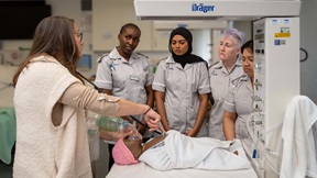 Four midwifery students and tutor with a medical mannekin