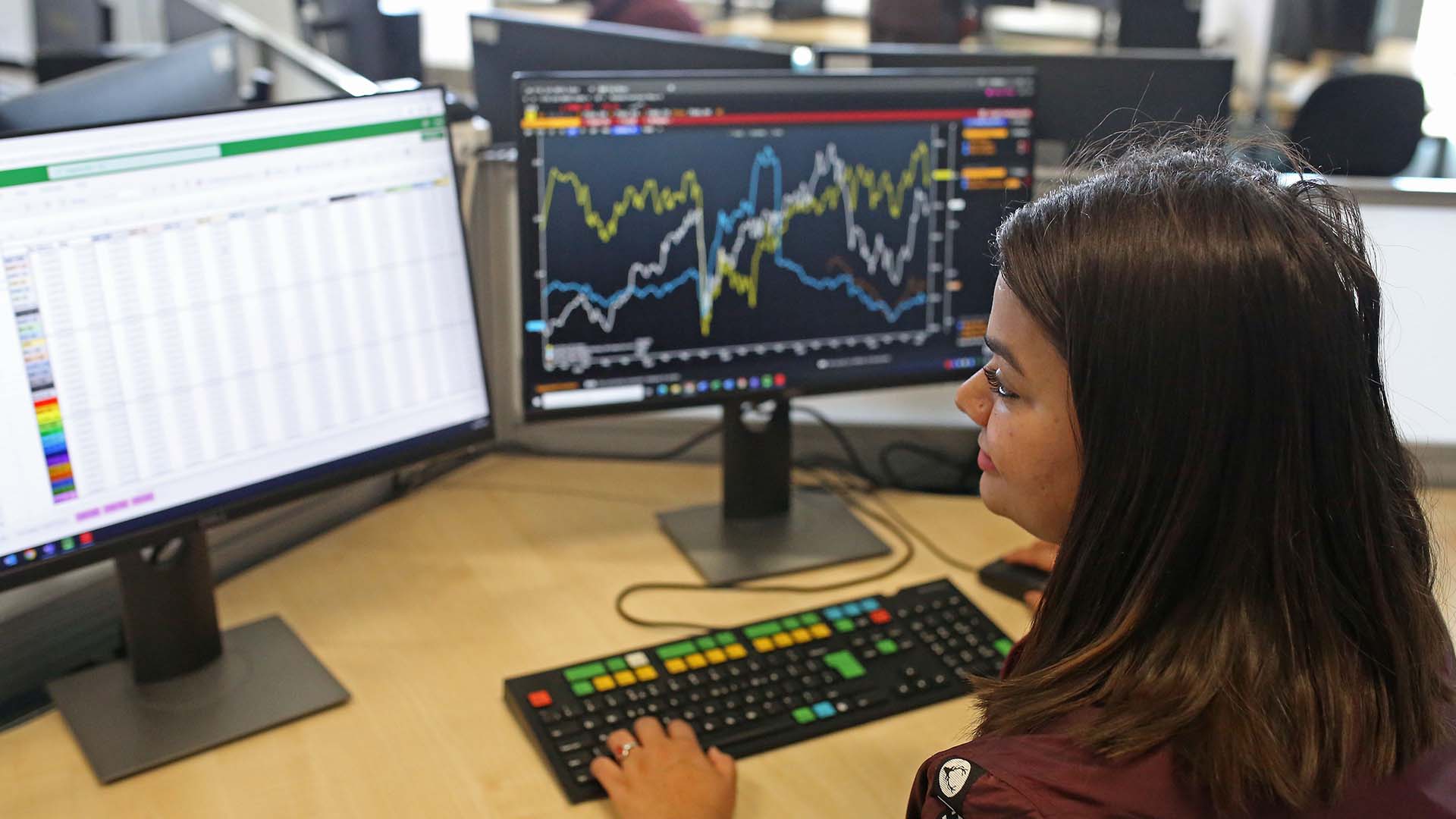 Student looking at computer monitors in the Bloomberg Financial Markets Lab at ARU Chelmsford