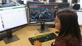 Student looking at computer monitors in the Bloomberg Financial Markets Lab at ARU Chelmsford
