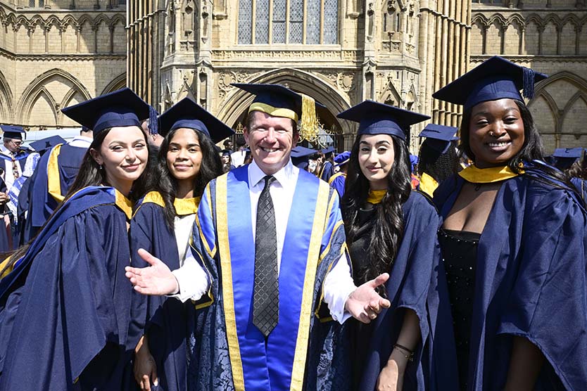 ARU Peterborough Principal Prof Ross Renton with four graduates at Peterborough Cathedral