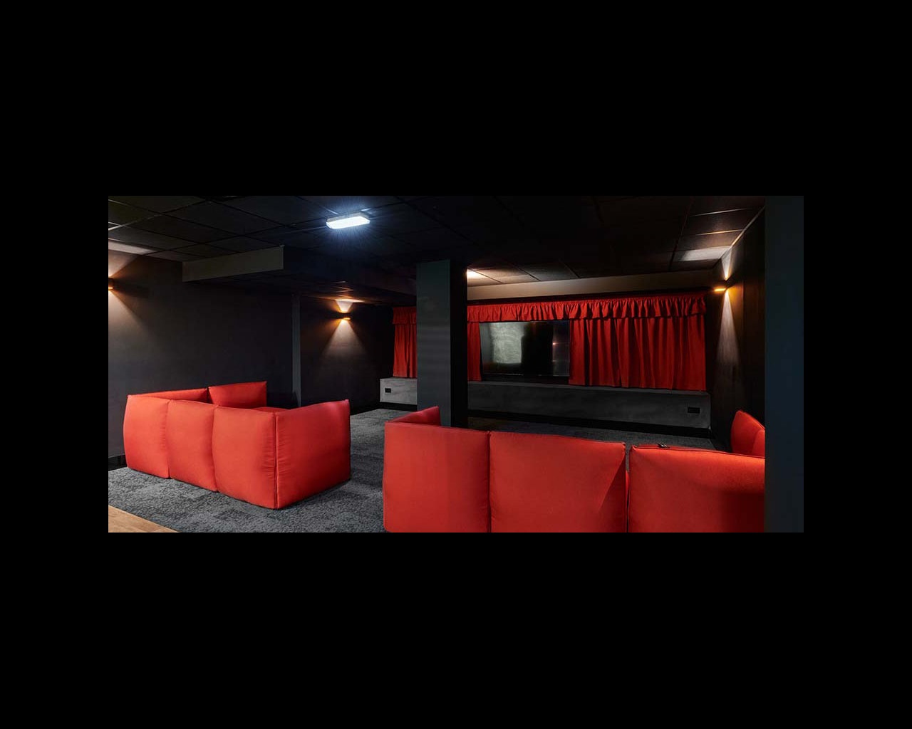 Sofas facing a TV in a darkened room, in Cambridge's CB1 accommodation