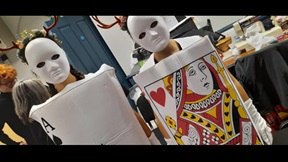 Two students dressed as playing cards with white masks and antlers