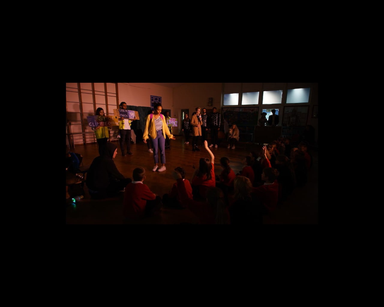 Student actors on stage performing to school audience
