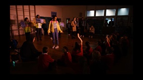 Student actors on stage performing to school audience