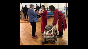 Two drama students dressed in red chinese-style costumes talking to lecturer