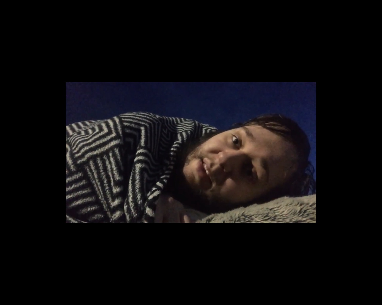 Film still of man lying in bed