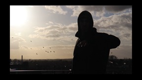 Film still of man dancing on rooftop at sunset