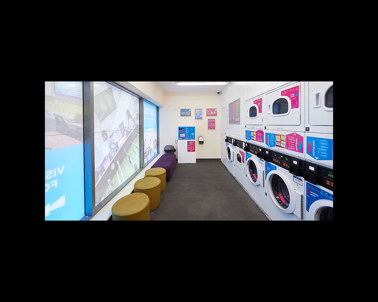Laundry room with washing machines and soft seating