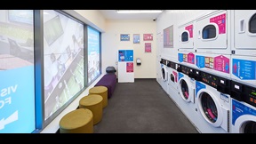 Laundry room with washing machines and soft seating