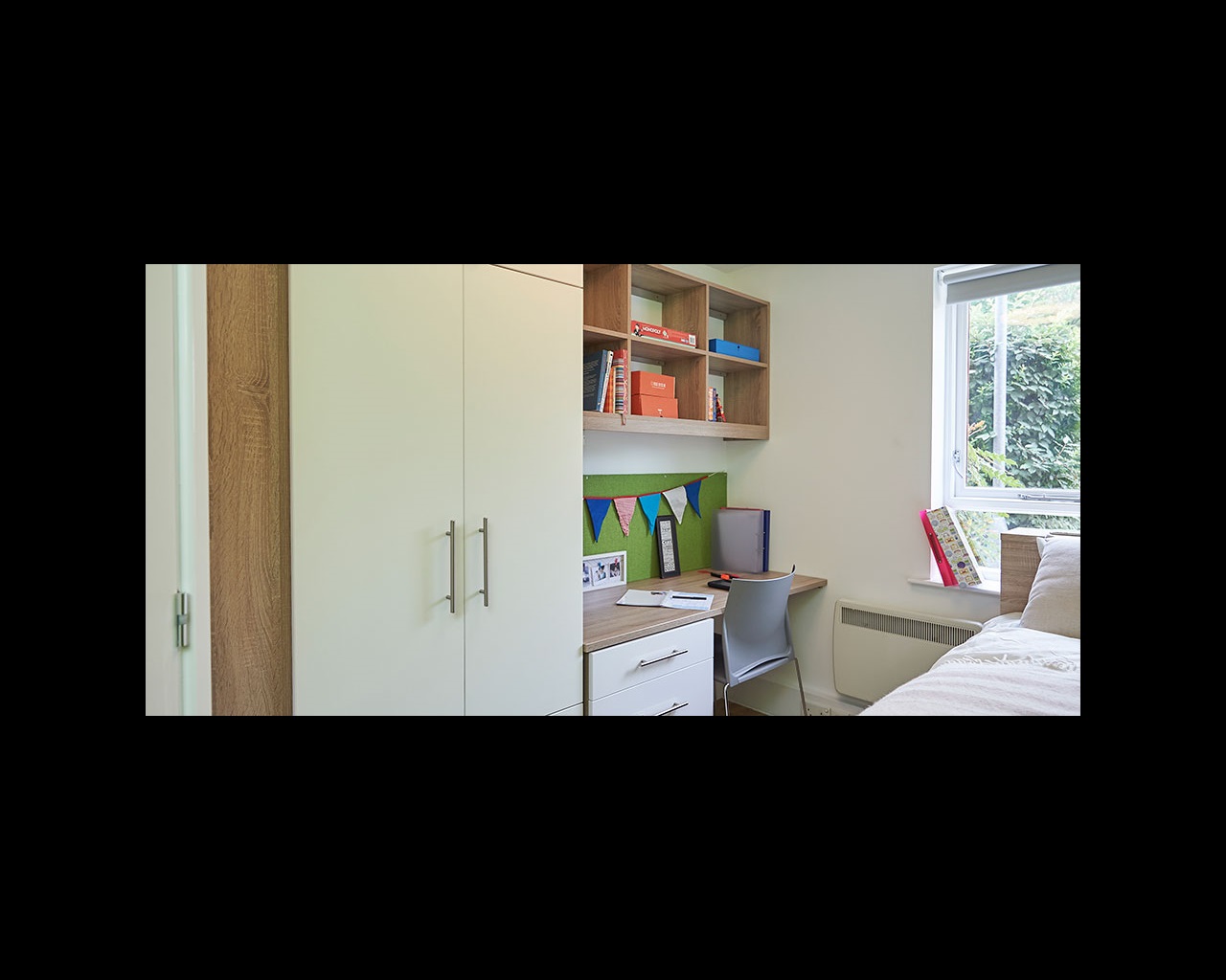 Bedroom with desk and wall-mounted bookshelf