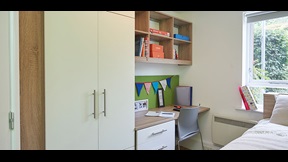 Bedroom with desk and wall-mounted bookshelf