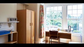 Wardrobe, desk and chair in front of windows